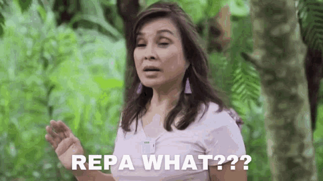 a woman in a purple shirt is standing in a forest and says repa what ?