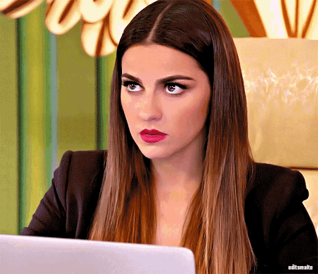 a woman with long hair is sitting in front of a laptop with the words editsmatts on the bottom