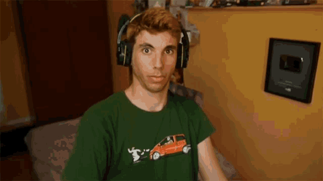 a man wearing headphones and a green t-shirt with a car on it
