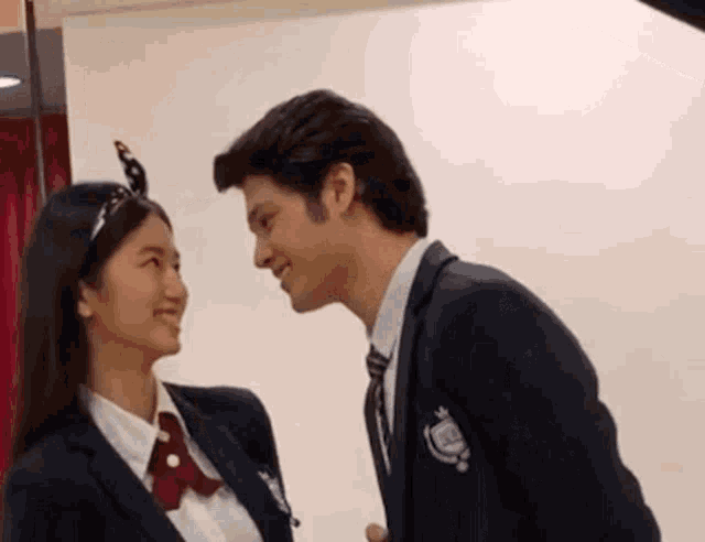 a man and a woman are looking at each other and kissing .