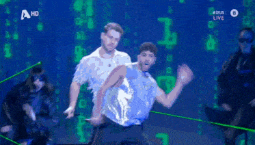 two men are dancing in front of a screen that says ' a hd ' on it