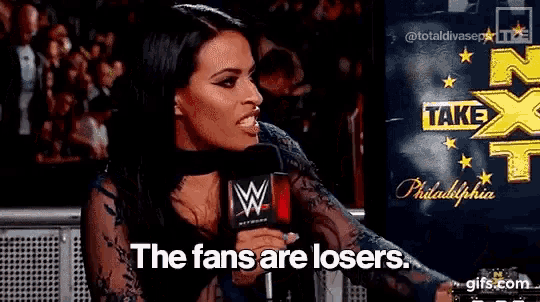a woman is talking into a microphone and saying the fans are losers