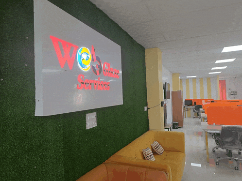 a yellow couch sits in front of a sign that says wea software services