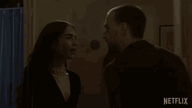 a man and a woman looking at each other with a netflix logo behind them