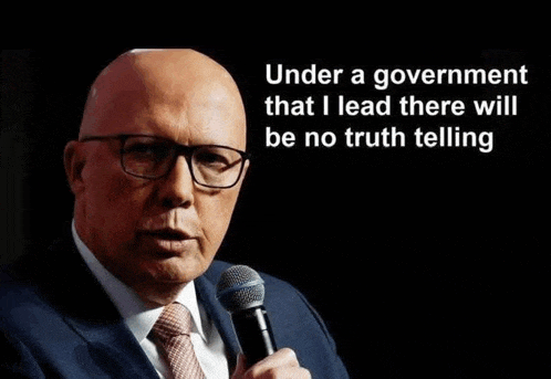a bald man in a suit and tie is holding a microphone and speaking into it .