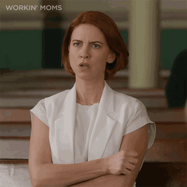 a woman with her arms crossed has the word workin ' moms written above her