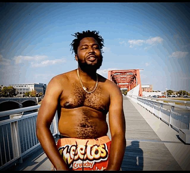 a shirtless man wearing cheetos crunchy shorts
