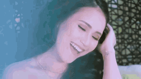 a woman is smiling while taking a bath in a bathtub .