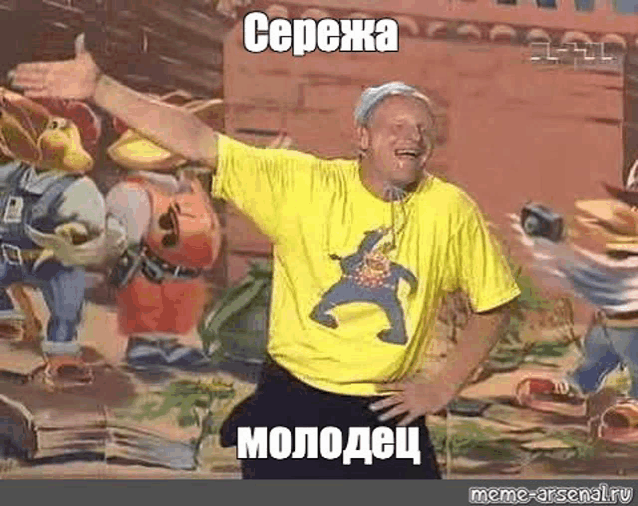 a man in a yellow t-shirt is giving a thumbs up in front of a cartoon wall .