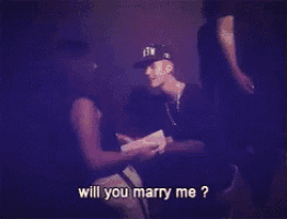 a man is kneeling down in front of a woman asking her to marry him