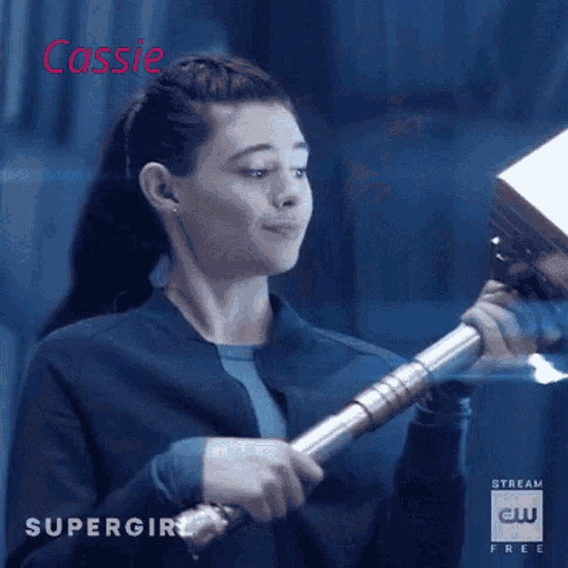a woman in a blue jacket is holding a hammer in her hand .