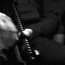 a black and white photo of a person holding a gun in their hand .