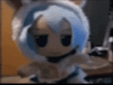 a stuffed doll with blue hair and white ears is dancing .