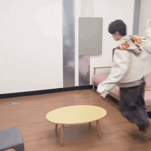 a man in a white jacket is running towards a yellow table