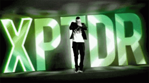 a man is standing in front of a large green xpdr sign