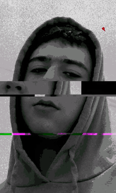 a black and white photo of a young man with a hood on