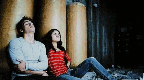 a man and a woman are sitting next to each other looking up