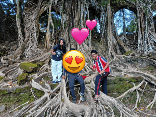 a group of people posing for a picture in front of a tree with a heart in the background
