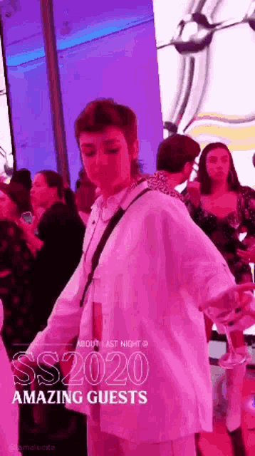 a woman in a white shirt is dancing in front of a crowd at a party sponsored by ss2020 amazing guests