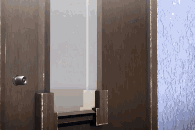 a wooden door with a window and a blue wall