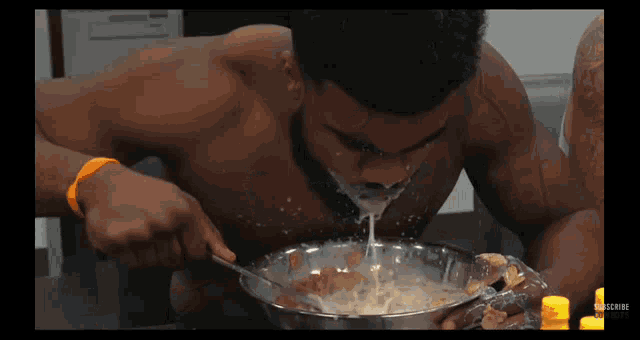 a shirtless man is eating cereal from a bowl