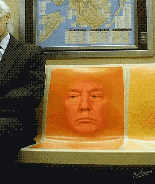 a man in a suit sits on a subway seat with a picture of donald trump behind him