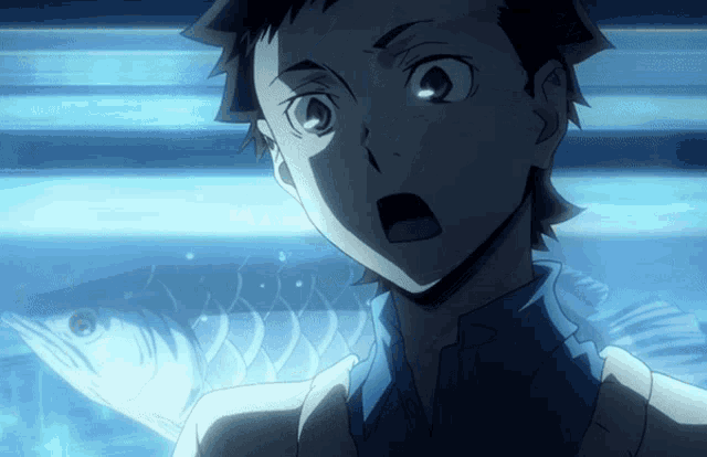 a boy is looking at a fish in an aquarium