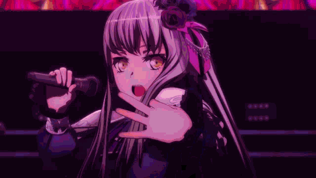 a girl in a black dress is singing into a microphone on a stage .