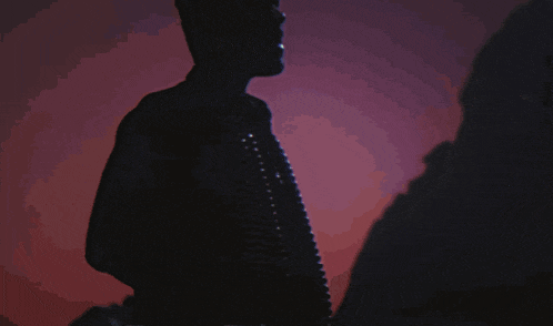 a silhouette of a man in a dark room with a purple and blue background