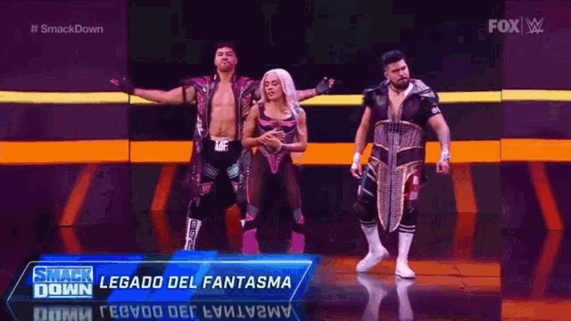 a group of wrestlers are standing on a stage in front of a fox advertisement .