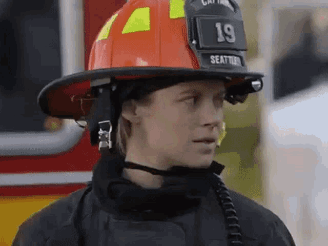 a female firefighter wearing a helmet with the number 19 on it .