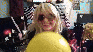 a blonde woman wearing sunglasses is holding a yellow ball