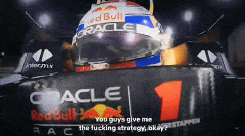 a man wearing a red bull helmet stands in front of a sign that says oracle