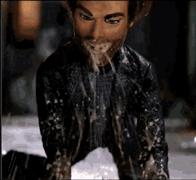 a close up of a man 's face with liquid coming out of his mouth