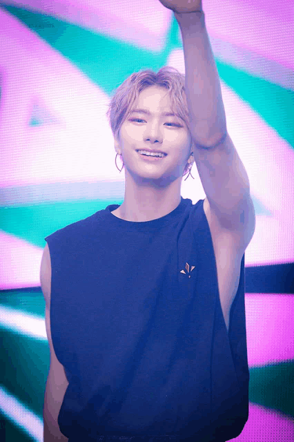 a man wearing a black tank top with a gold emblem on it