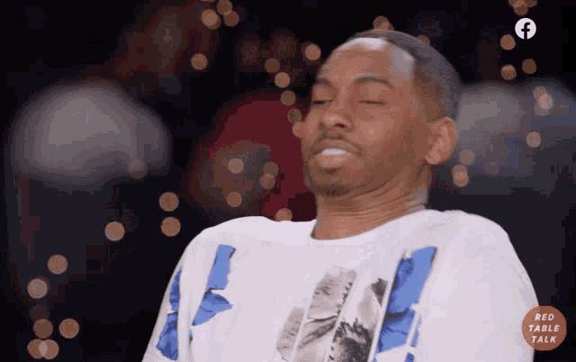 a man with his eyes closed is wearing a shirt that says red table talk on it