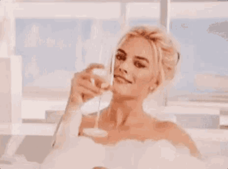 a woman in a bathtub drinking champagne with the words vc merece champanhe below her