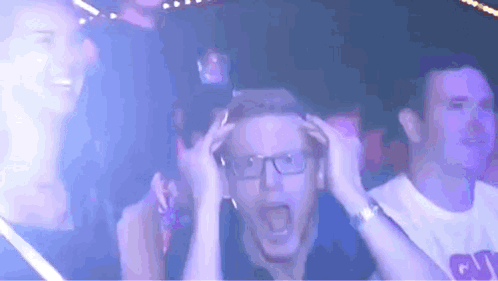 a man with glasses is screaming in a crowd of people wearing a shirt that says giants