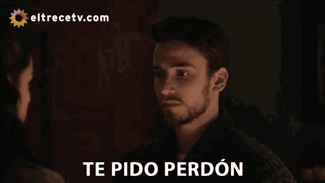 a man with a beard is looking at another man with the words te pido perdon below him