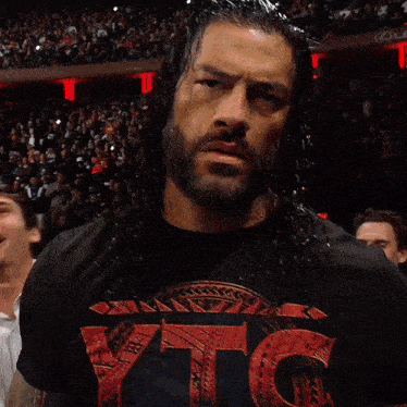 a man wearing a black shirt that says dc is standing in front of a crowd