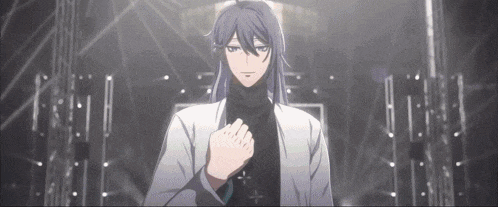 a man with long hair and a turtleneck is standing in a dark room .
