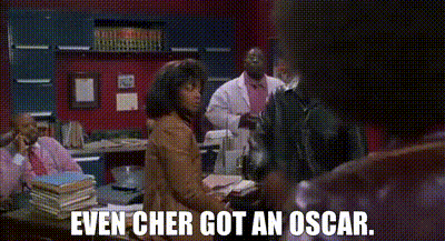 a woman sitting at a desk with the words even cher got an oscar written on the bottom