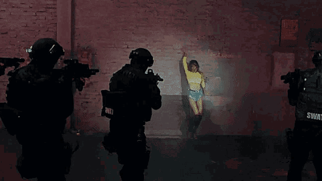 swat officers are looking at a woman in a yellow top