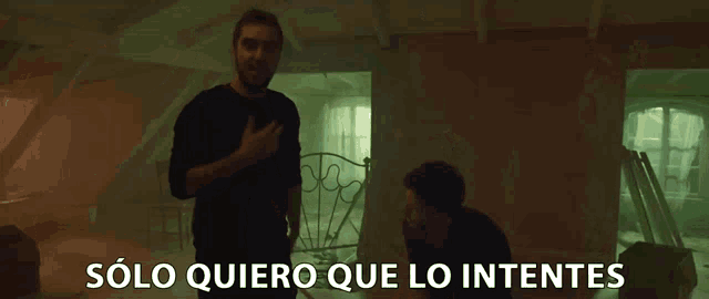 two men standing in a dark room with the words solo quiero que lo intentes written on the bottom