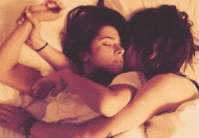 two women are hugging each other on a bed