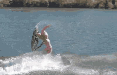 a person in a pink suit is riding a wave on a surfboard