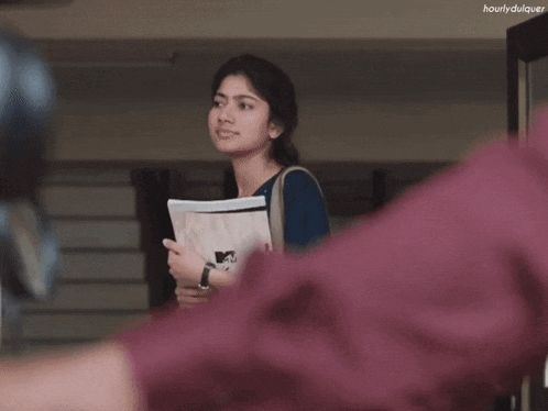 a girl with a book in her hand is standing in front of a door that says hourlyduquer on it
