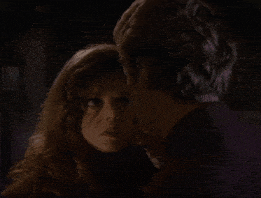 a close up of a man 's face with a woman 's head behind it