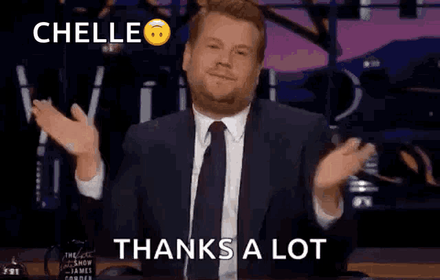 a man in a suit and tie is giving a thumbs up .