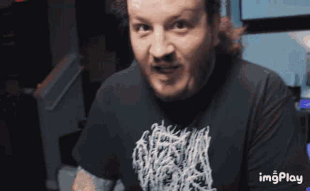 a man wearing a black shirt that says imgplay on the bottom